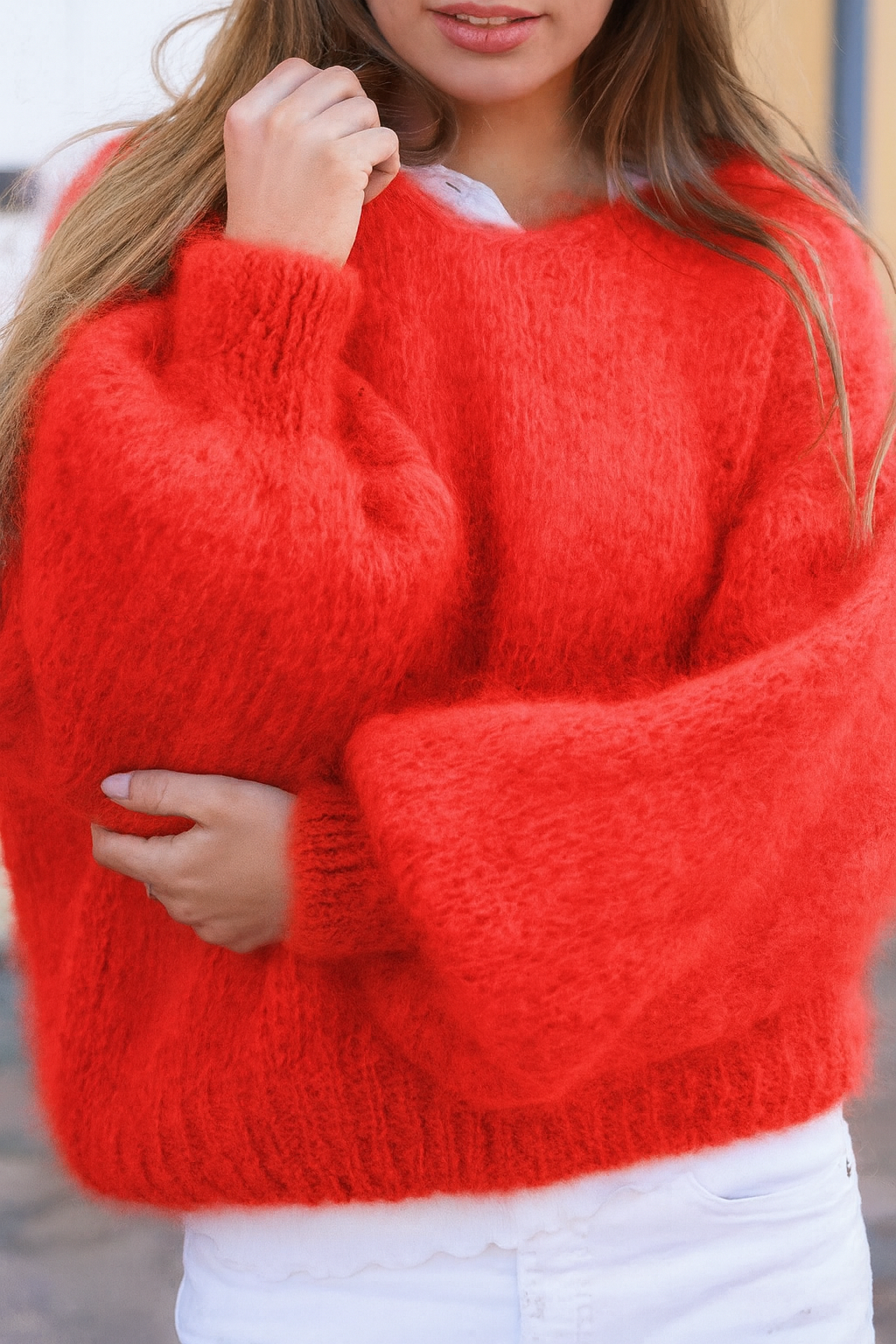 Person wearing a red sweater with a blurred background